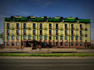 a large yellow building with a green roof at Apart-Hotel Camelot in Pskov