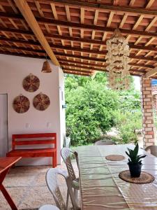 a table and chairs on a patio with a bench at Aguapé 4 in Barreirinhas