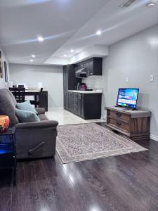 a living room with a couch and a flat screen tv at Bernie's Basement in Milton