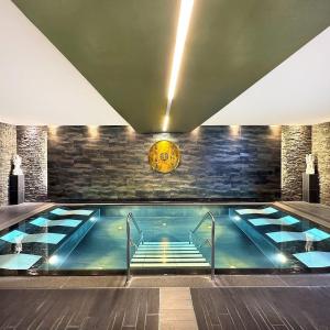a swimming pool in a building with a clock on the wall at Becci Apartment-Free Parking in Kapfenberg