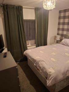 a bedroom with a bed and a chandelier at No 1 The Glen in Port Seton
