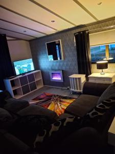 a living room with a couch and a tv at No 1 The Glen in Port Seton