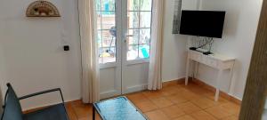 a living room with a tv and a window at Ti Cactus Guadeloupe in Sainte-Rose