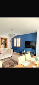 a living room with a white couch and a blue wall at New Holliday Villa, Anstruther in Cellardyke