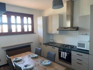 a kitchen with a wooden table with chairs and a stove at Residenza Ticino in Oleggio