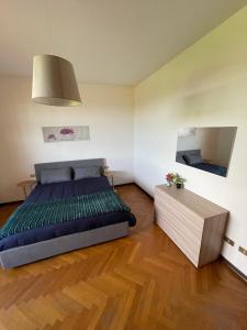 a bedroom with a large bed and a wooden floor at Residenza Ticino in Oleggio