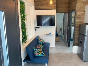 a living room with a blue couch and a tv at Gîte T2 cosy indépendant tout confort in Vieux-Fort