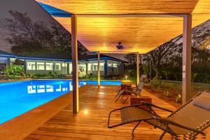 a wooden deck with a swimming pool and a house at Casa Frank - Sophiassuites506 in Brasilito