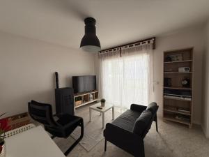 a living room with a couch and a tv at Casa Ángel 1982 in Oia