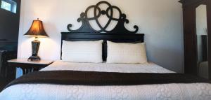 a bedroom with a bed with a black headboard and a lamp at 1895 Washington Hotel in Paducah