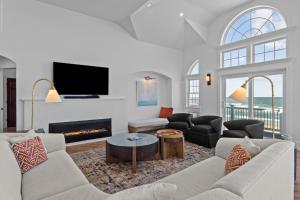 a living room with a couch and a fireplace at 2876 - The Blue Martini in Duck