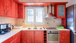 a kitchen with wooden cabinets and a sink and a window at Filoxenia in Alepou +5 photos