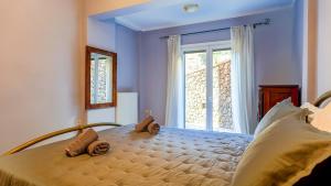 a bedroom with a large bed with a window at Filoxenia in Alepou
