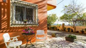 a patio with chairs and a window on a building at Filoxenia in Alepou