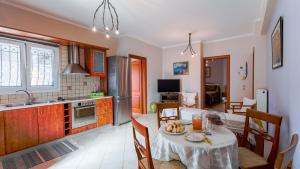 a kitchen and a dining room with a table and a kitchen at Filoxenia in Alepou