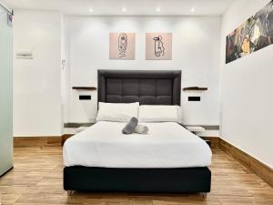 a bedroom with a large white bed and paintings on the wall at Ilustre Rooms Malaga in Málaga