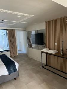 a bedroom with a bed and a flat screen tv at Modern Ground Floor Apartment in Ghent