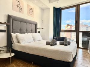 a bedroom with a large bed with a large window at Ilustre Rooms Malaga in Málaga