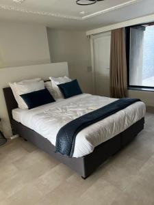 a bedroom with a large bed with blue pillows at Modern Ground Floor Apartment in Ghent