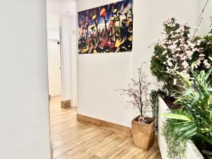 a hallway with plants and a painting on the wall at Ilustre Rooms Malaga in Málaga