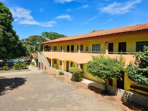 a yellow building with a road in front of it at Pantanal Hotel in Miranda