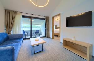 a living room with a blue couch and a tv at Mamin san in Cres