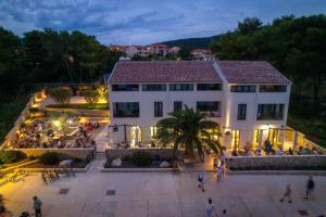 a large white building with people standing outside of it at Mamin san in Cres