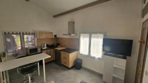 a kitchen with a desk and a tv in a room at Appartement paisible in Saint-Cyprien