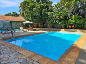 a swimming pool with blue water in a yard at Pantanal Hotel in Miranda
