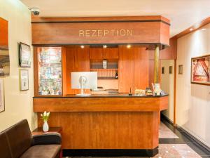 a bar in a restaurant with a reception counter at Parkhotel Friedrichstrasse in Gießen