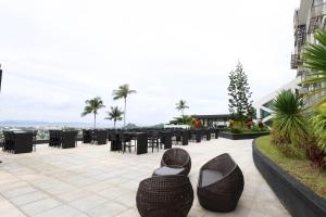 a patio with black tables and chairs and shoes at The Oriental Hotel Legazpi in Legazpi