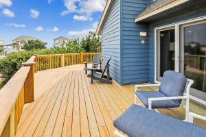 a wooden deck with two chairs on a house at 3979 - Wright by the Coast in Duck