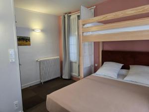a bedroom with a bunk bed and a window at Hotel le Saint Germain in Flers