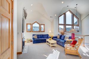 a living room with a blue couch and windows at 4052 - Mirth N Mist II in Duck