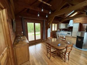 a kitchen and dining room with a table in a cabin at écrin d'éveil in Campagne-lès-Guînes