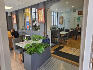 a restaurant with tables and chairs and people sitting at tables at Hotel le Saint Germain in Flers