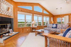 a living room with a couch and a fireplace at 3213 - Seaside Salvation in Duck