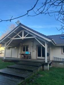 a house with a porch and a deck at écrin d'éveil in Campagne-lès-Guînes