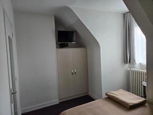 a room with a bed and a tv on a wall at Hotel le Saint Germain in Flers