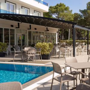 a patio with tables and chairs next to a pool at Hotel Miami II in Golem