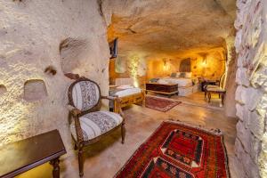 a bedroom with a bed and a couch in a cave at Lubberona Cave Cappadocia in Nar