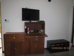 a wooden entertainment center with a flat screen tv on top at Zee's Garden in Matale