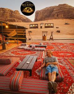 a woman sitting on a rug in the desert at Star night in Disah +48 photos