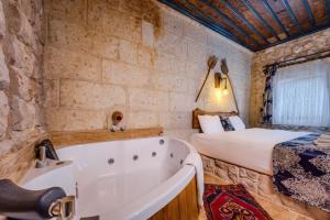 a bedroom with a bed and a tub in a room at Lubberona Cave Cappadocia in Nar +84 photos