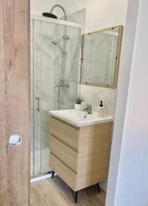 a bathroom with a sink and a shower with a mirror at La Dolce Loca in Orange