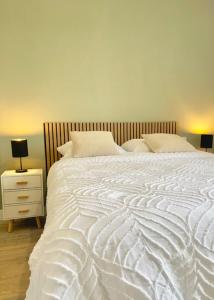 a bedroom with a large white bed and a nightstand at La Dolce Loca in Orange