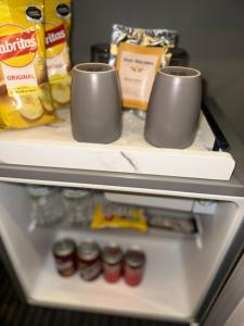 a refrigerator with two cups on top of it at Hotel Boutique Querencia in Tijuana