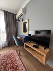a living room with a television and a chair at Avenue Aparthotel in Sofia