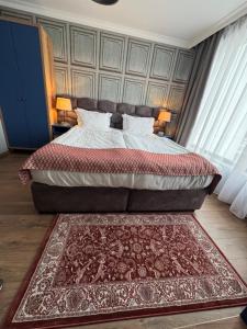 a bedroom with a large bed with a rug at Avenue Aparthotel in Sofia