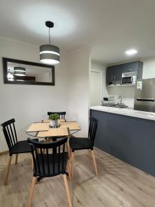a dining room and kitchen with a table and chairs at Agradable y Acogedora Casa Moderna en Puerto Varas in Puerto Varas